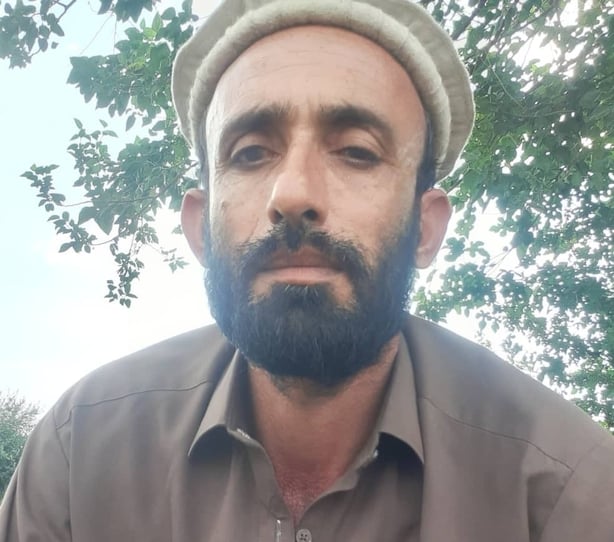 Abdul Hadi Sarwari looks directly at the camera lens in front of a tree.