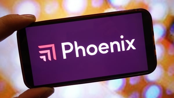 Image a hand holding a smartphone with the Phoenix logo