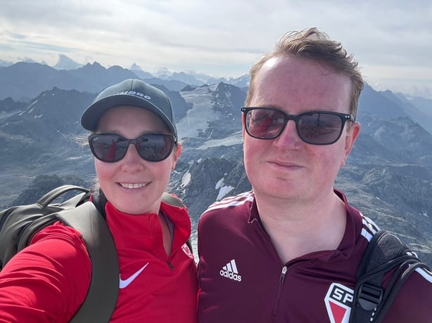 A woman talking a selfie of her and her partner while hiking