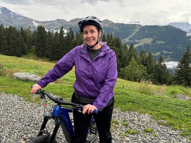 A woman posing with a bike on a mountain