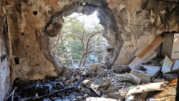 A drone strike leaves a large hole in a wall of an apartment block