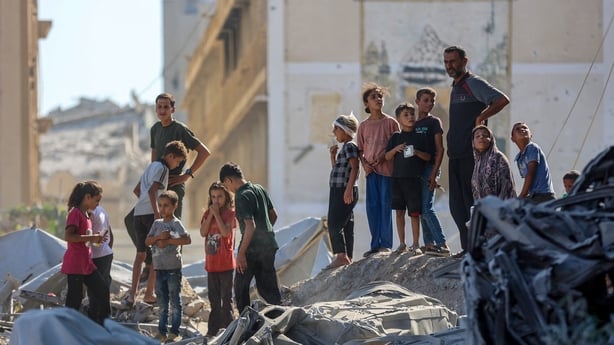 Palestinians check the rubble of al-Ruya Tower in Gaza City's Rimal area following the Israeli strike