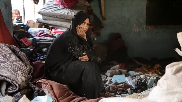 A displaced Palestinian woman sits amid the rubble inside a classroom