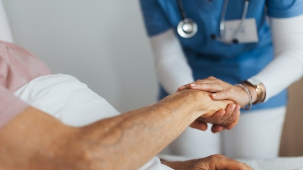 Close-up of caregiver holding senior client hand