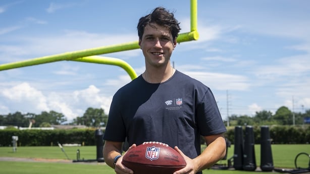 Charlie Smyth standing with an american football in his hands in front of the posts
