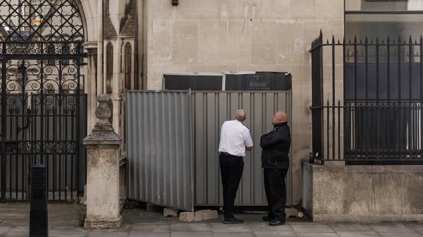 Security guards stand in front of what is believed to be a new mural by the street artist Banksy at The Royal Courts of Justice on September 08, 2025 in London, England. Banksy posted a photograph of his latest mural on the side of the Royal Courts of Justice today, depicting a Judge beating a prote