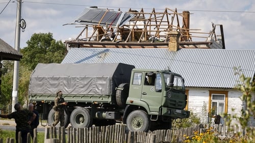 Police and army inspect damage to a house destroyed by debris from a shot-down Russian drone in the village of Wyryki-Wola, eastern Poland