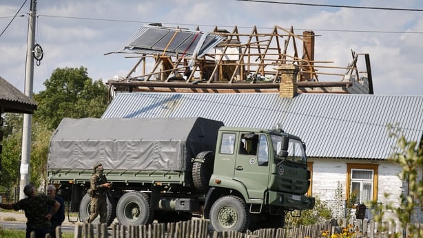 Police and army inspect damage to a house destroyed by debris from a shot down Russian drone in the village of Wyryki-Wola