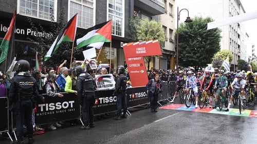Pro-Palestinians protesters wave Palestinian flags at the start of the 17th stage of the Vuelta a Espana