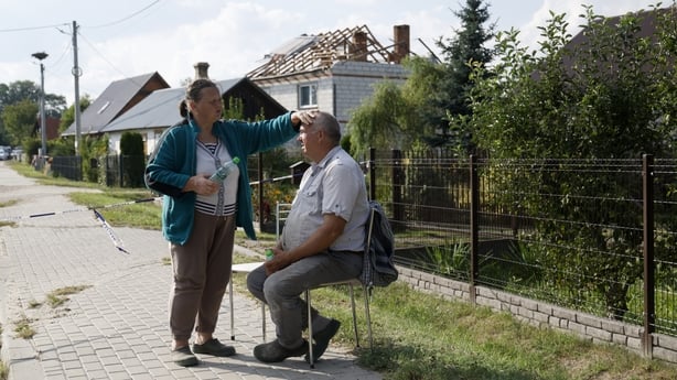 Alicja Wesolowska and her husband Tomasz Wesolowski sit in front of their damaged house destroyed by debris from a shot down Russian drone