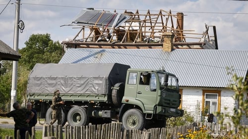 Police and army inspect damage to a house destroyed by debris from a shot down Russian drone in the village of Wyryki-Wola