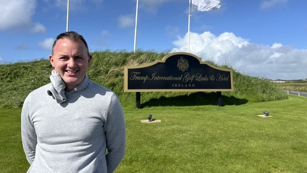 Local golfer David Tubridy stands in front of Trump International Golf Club sign in