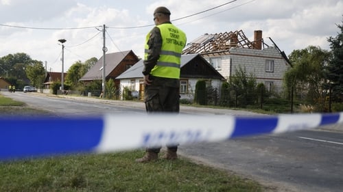 Police inspect damage to a house destroyed by debris from a shot down Russian drone in the village of Wyryki-Wola, Poland