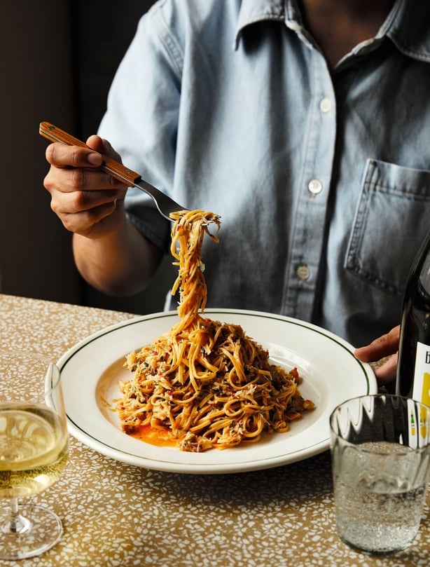 A man taking a forkful of pasta from a plate