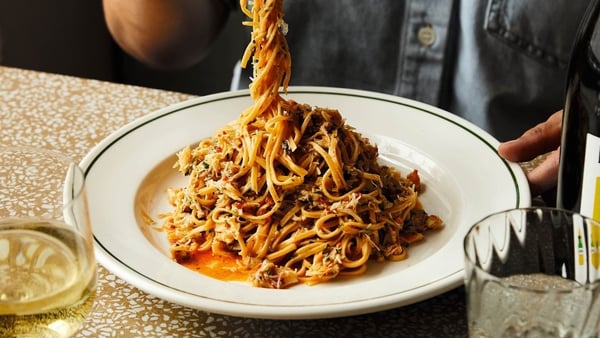 A man taking a forkful of pasta from a plate