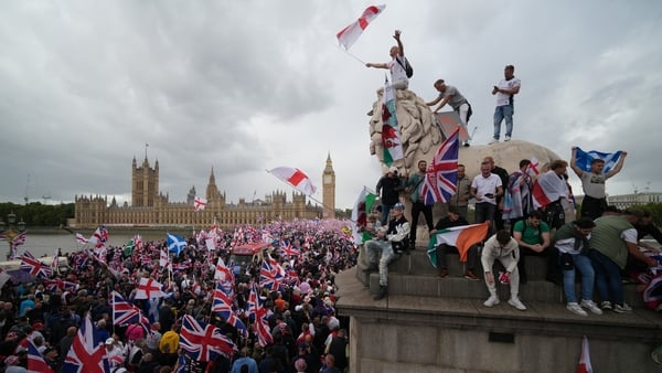 LONDON, ENGLAND - SEPTEMBER 13: Protesters wave Union Jack and St George's England flags during the "Unite The Kingdom" rally on Westminster Bride by the Houses of Parliament on September 13, 2025 in London, England. Far-right activist Tommy Robinson (als