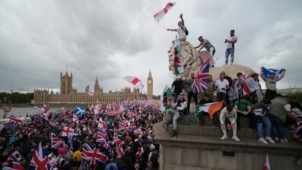 LONDON, ENGLAND - SEPTEMBER 13: Protesters wave Union Jack and St George's England flags during the "Unite The Kingdom" rally on Westminster Bride by the Houses of Parliament on September 13, 2025 in London, England. Far-right activist Tommy Robinson (also known as Stephen Yaxley-Lennon) has invited