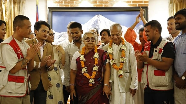 Nepal's new PM Sushila Karki stands with her supporters after her swearing in ceremony