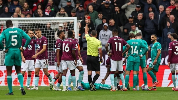 Burnley's Lesley Ugochukwu (kneeling) is shown a red card by Referee Michael Oliver during the Premier League match between Burnley and Liverpool at Turf Moor on September 14, 2025 in Burnley, England.