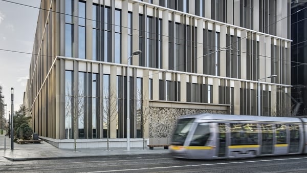 Image of a new office block with a Luas tram driving by it
