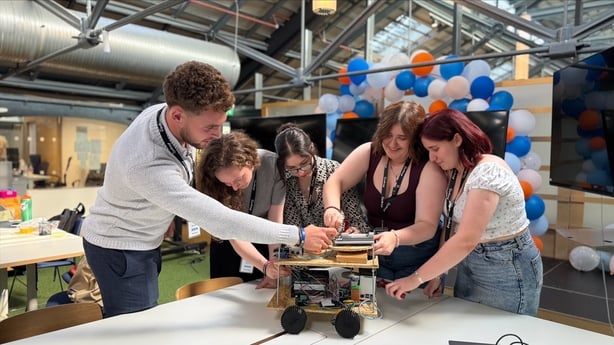 Five students working on the prototype of an AI-driven rover to treat ash dieback