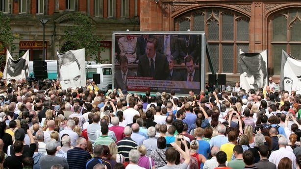 People watch Prime Minister David Cameron on a giant screen making a statement to the House of Commons regarding the findings of the Saville Inquiry into Bloody Sunday, outside the Guildhall in Derry.
