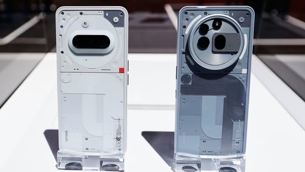 Two Nothing smartphones on a stand