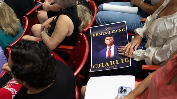 An attendee holds a poster of Turning Point USA founder Charlie Kirk during a vigil at Desert Financial Arena on the campus of Arizona State University (ASU) in Tempe, Arizona, US, on Monday, Sept. 15, 2025. Kirk, 31, the executive director of Turning Point USA and an ally of President Donald Trump,