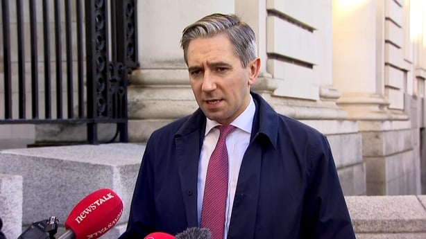 Simon Harris in front of microphone