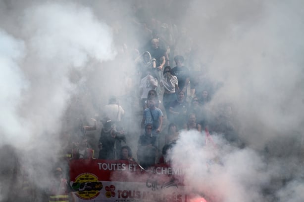 Demonstrators march with flares in the French city of Lyon during nationwide budget protests