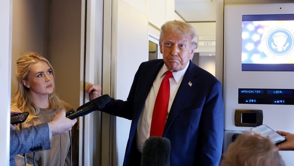 Donald Trump speaks to media on board the US presidential plane