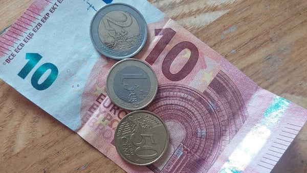 10 euro note with a two euro, one euro and 50 cent coin