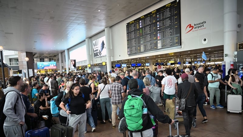 Travellers in Brussels Airport await information on the status of their flights after a cyber attack impacted the airport