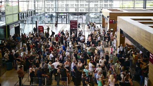 Passengers queue for check-in at Terminal 1 of Berlin Brandenburg amid the cyber attack disruption