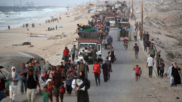 Displaced Palestinians move with their belongings southwards on a road in the Nuseirat refugee camp area in central Gaza