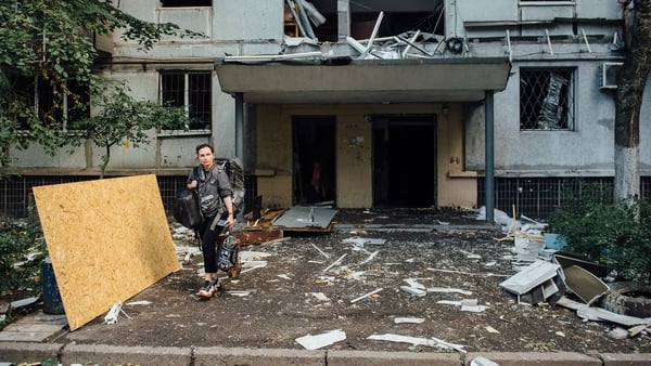 People clean up the aftermath of a Russian missile attackin Dnipro, Ukraine