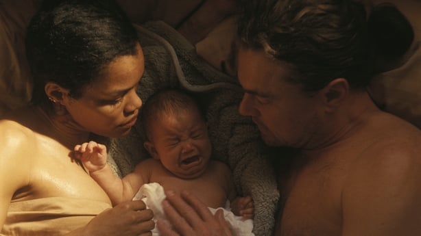 Teyana Taylor as Perfidia and Leonardo DiCaprio as Bob Ferguson share a tender moment with their baby in One Battle After Another
