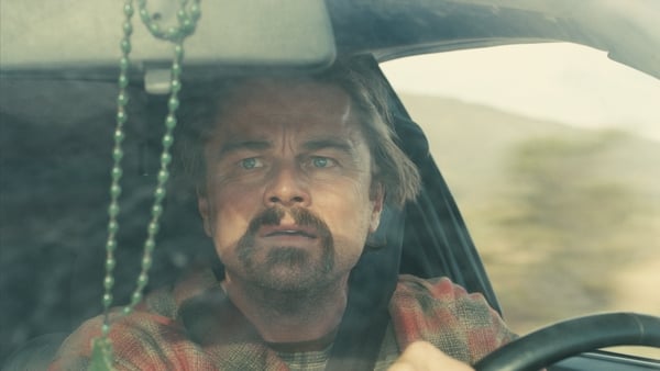 Leonardo DiCaprio looks anxiously in the rear-view mirror as Bob Ferguson in One Battle After Another