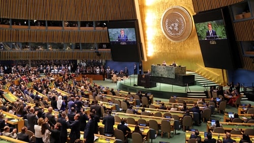 Delegates applaud French President Emmanuel Macron as he finishes speaking during a United Nations Summit