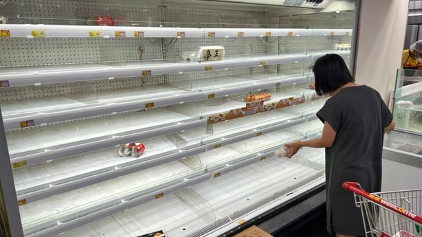 A woman is pictured in front of empty shelves at a supermarket in Hong Kong ahead of Super Typhoon Ragasa