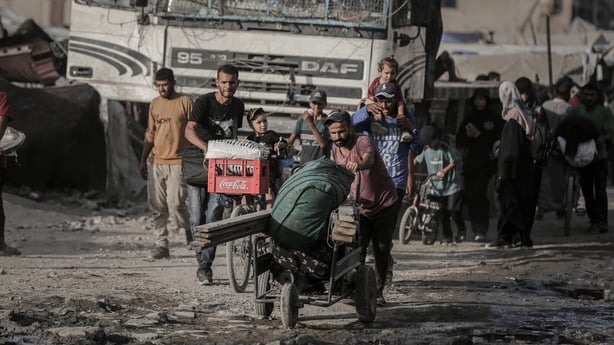 Displaced Palestinians walk from Gaza City along the coastal Al-Rashid Street