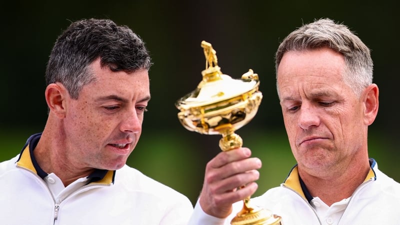 Rory McIlroy examines the silverware with European captain Luke Donald after victory over the USA last month