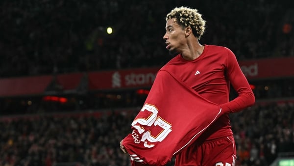 Liverpool's French striker #22 Hugo Ekitike starts to remove his shirt as he celebrates scoring their second goal, he was then sent off after picking up his second yellow card, during the English League Cup third round football match between Liverpool and