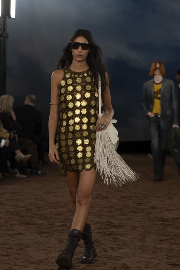 A model wearing a gold patterned mini dress