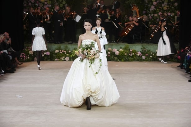 A model wearing a wedding gown with a full skirt