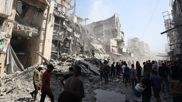 Palestinians inspect the rubble at the Bank of Palestine in Gaza City