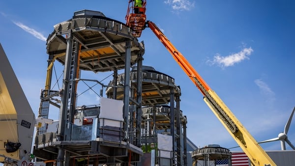 Wind turbine foundation components being manufactured with a crane in focus