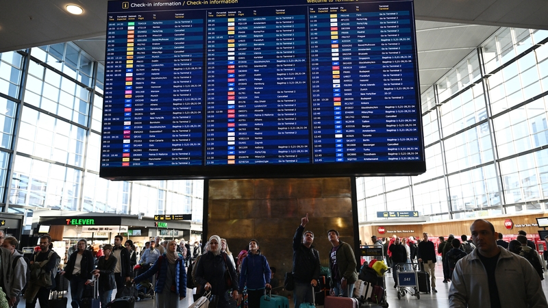 Passengers checking a flight information board at Copenhagen Airport on Tuesday