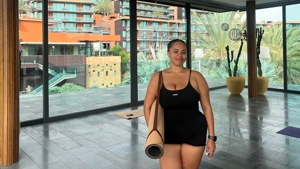 A photo of the author with a yoga mat in her arms