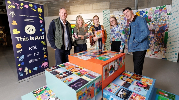 Five people, 2 men and 3 women, standing in front of a display unit at an art studio.
